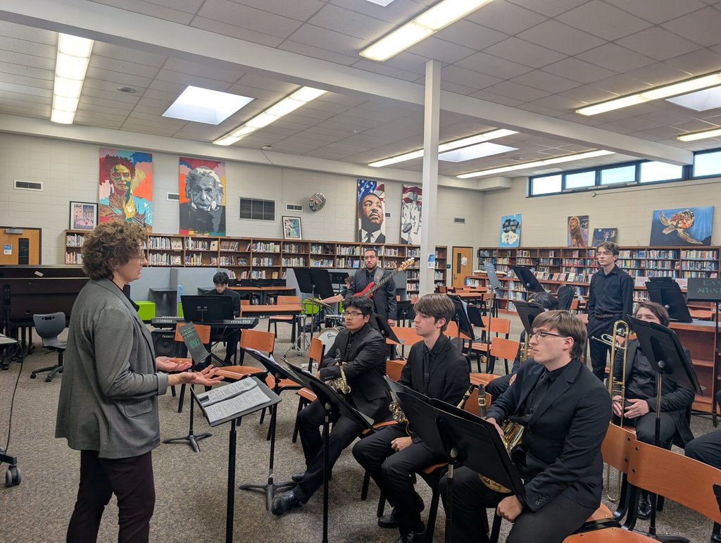 Image of the jazz ensemble practicing in the library of the school. 