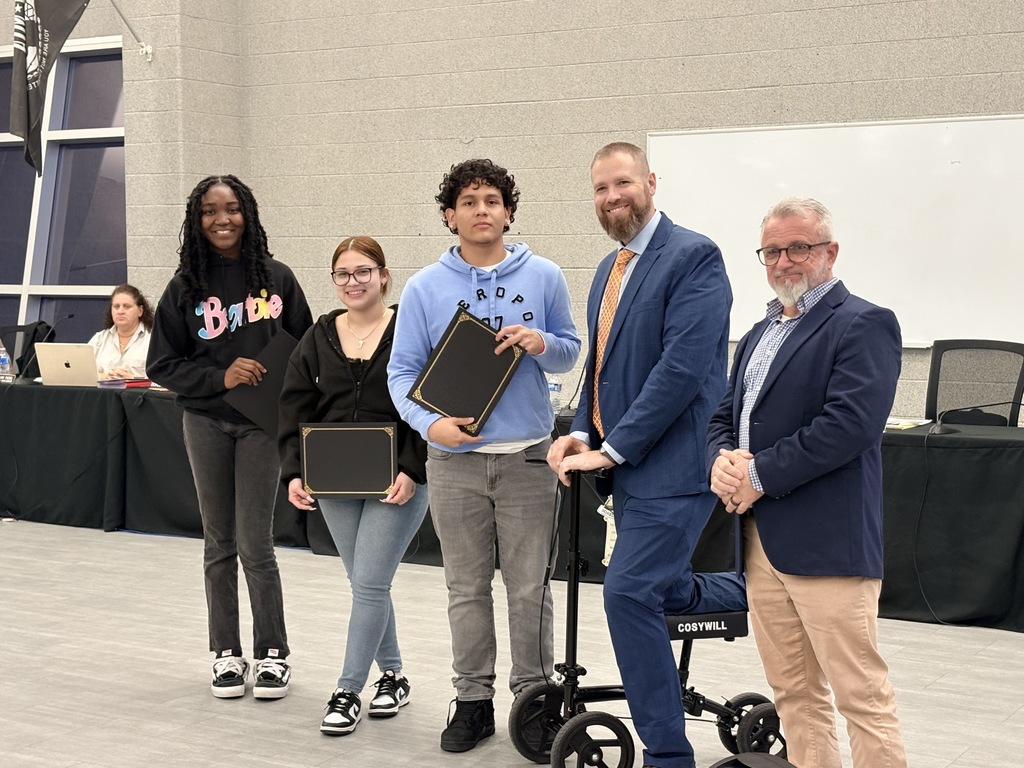 Image of the Seniors who attended the BOE meeting and received the Seal of Biliteracy recognition holding their certificates posing with the Superintendent and Board President.  