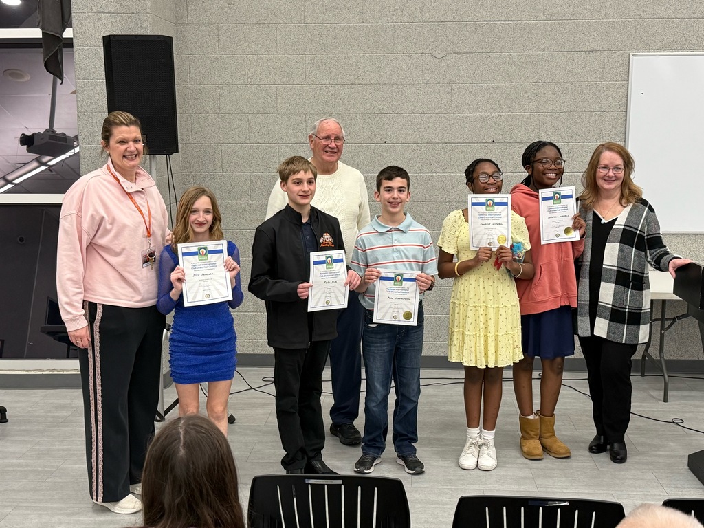 Image of the five Optimist Oratorical Contest winners holding their certificates and posing with the Ms. Spain, Mrs. Cooper, and the contest representative. 