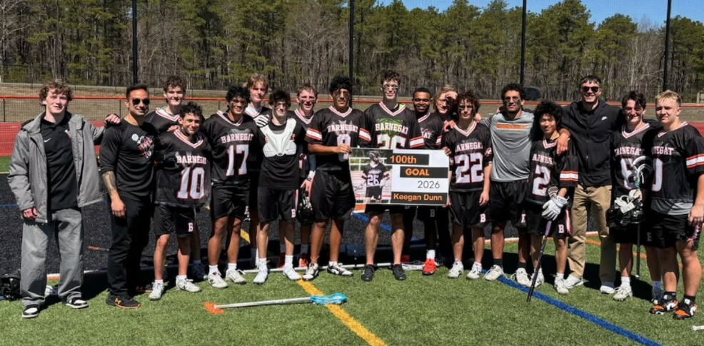 Image of the boys lacrosse team holding a sign in support of Keegan's 100th goal. 