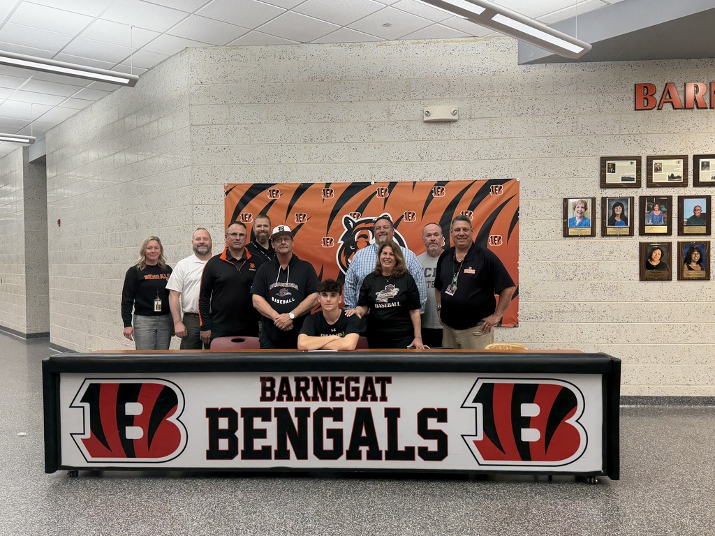Image of Raymond posing with his coaches, family, and building & district administrators. 