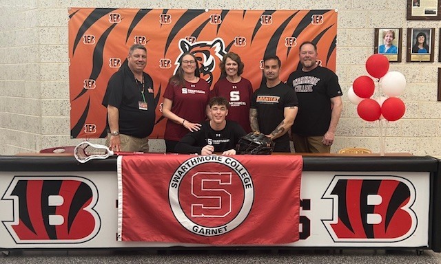 Image of Keegan posing with his family, coach, and the Director of Athletics. 