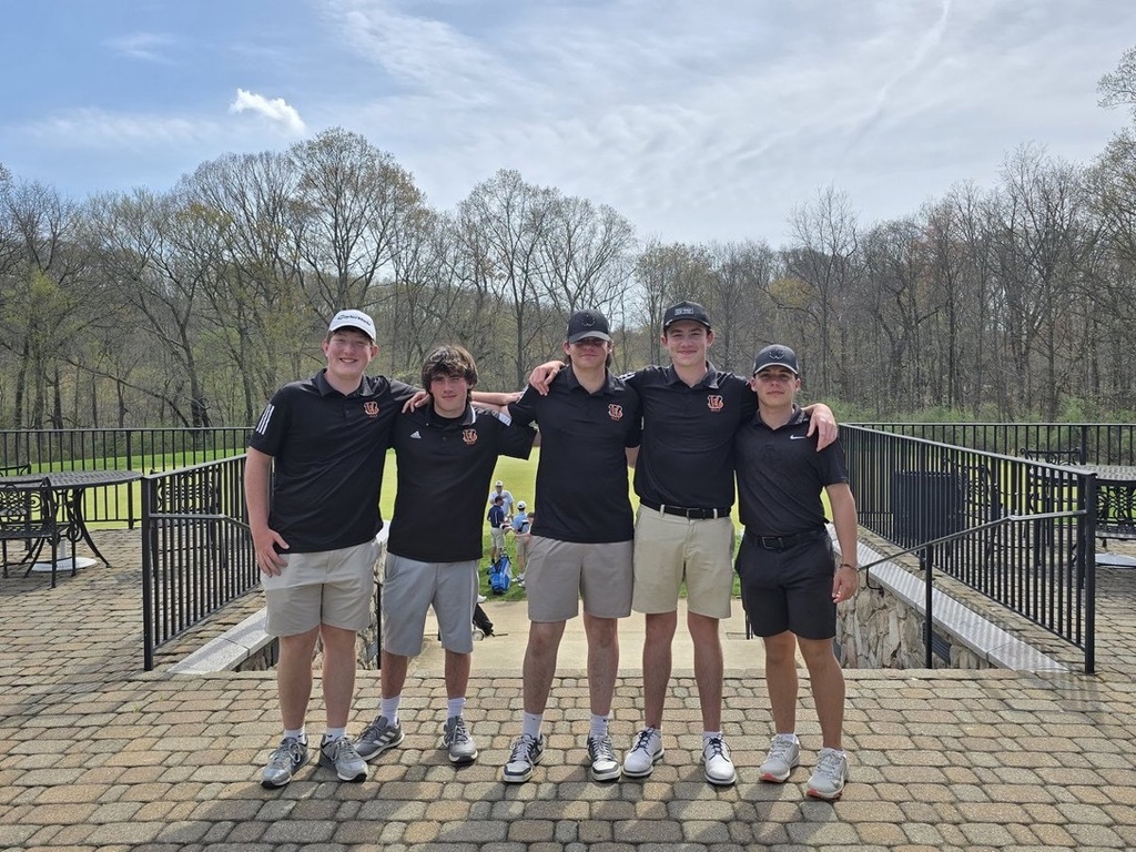 Image of the five boys on the boys' golf team posing together with their arms around each others shoulders. 