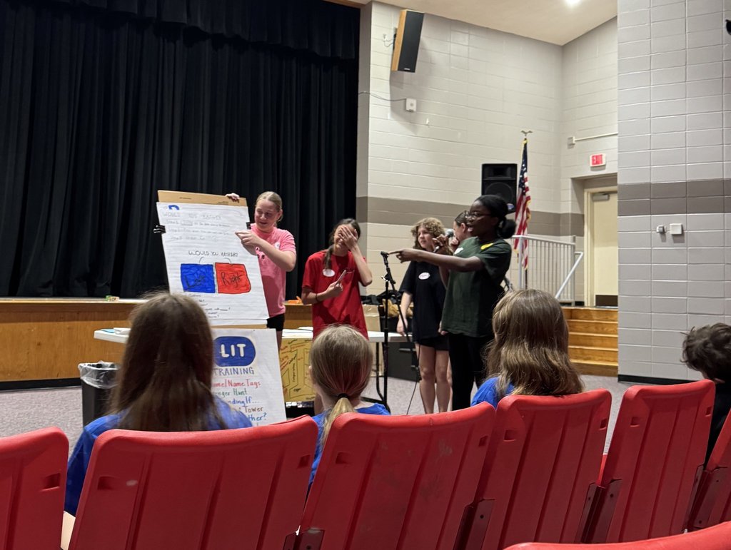 Image of a group of five ROBMS students teaching an activity to the RLHS  students. 