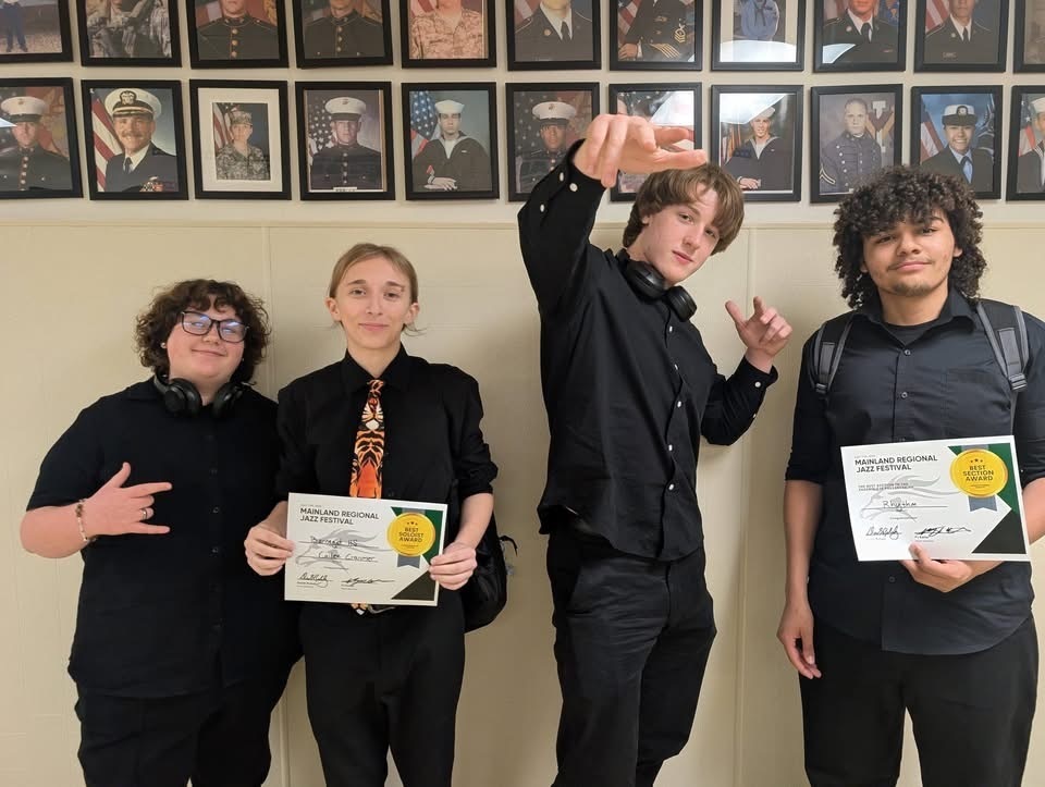 Image of the four members of the rhythm section posing holding the certificates. 