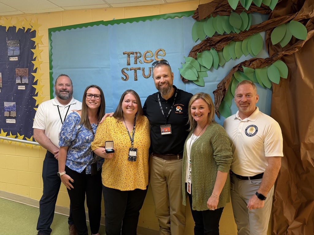 Image of Morgan posing with the Superintendent, district, and building administrators. 