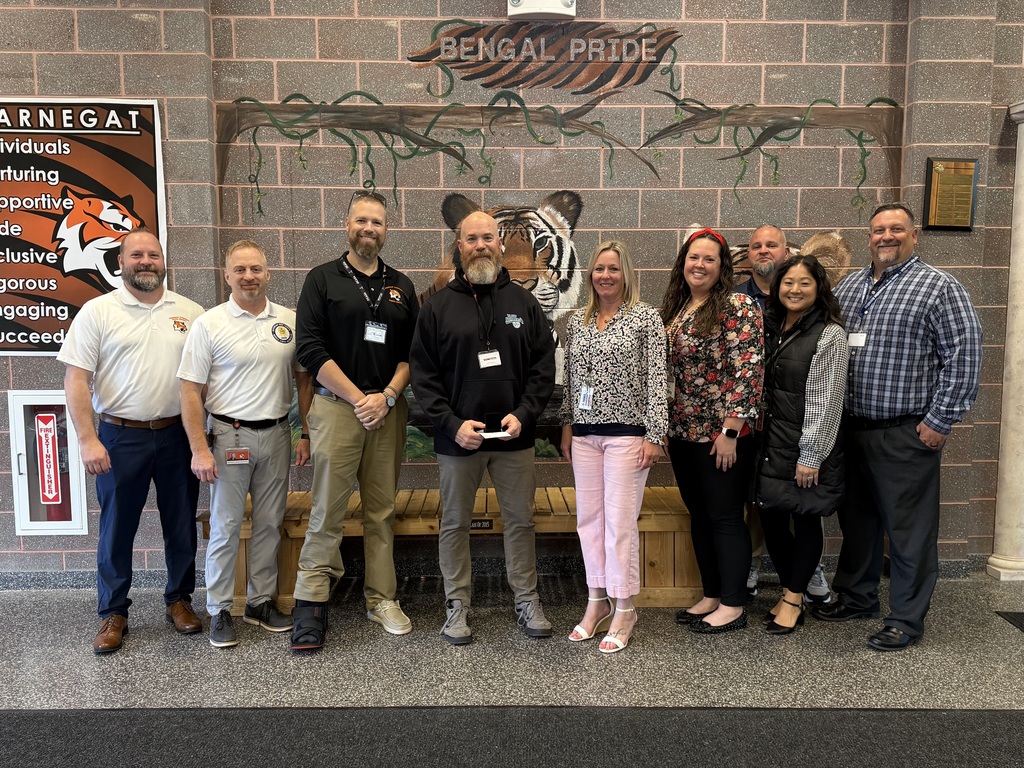 Image of Thomas posing with the Superintendent, district, and building administrators. 