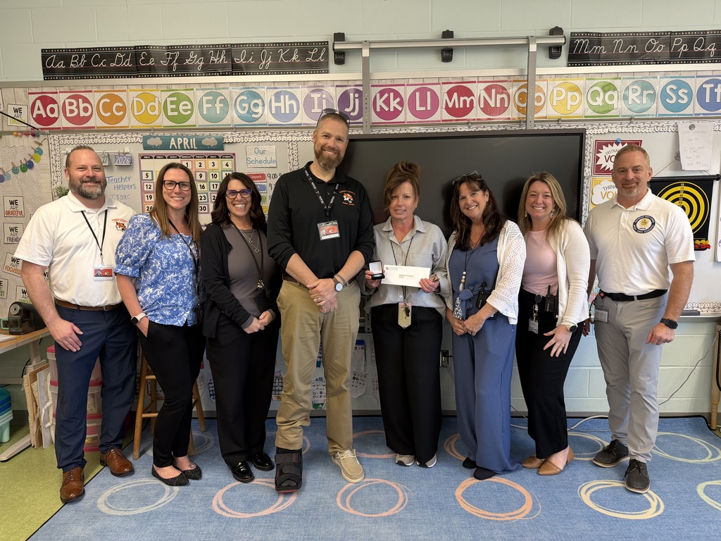 Image of Margaret posing with the Superintendent, district, and building administrators. 