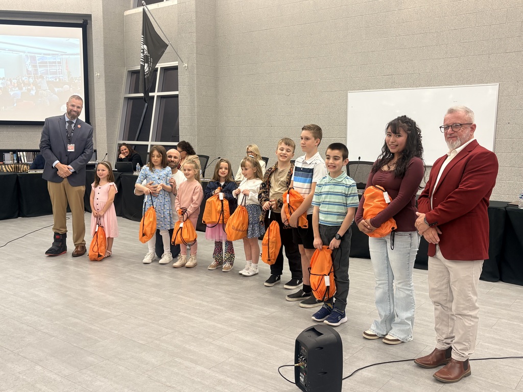 Image of the PFAC Drawing Contest winners holding their cinch bags and posing with the Superintendent and BOE President. 