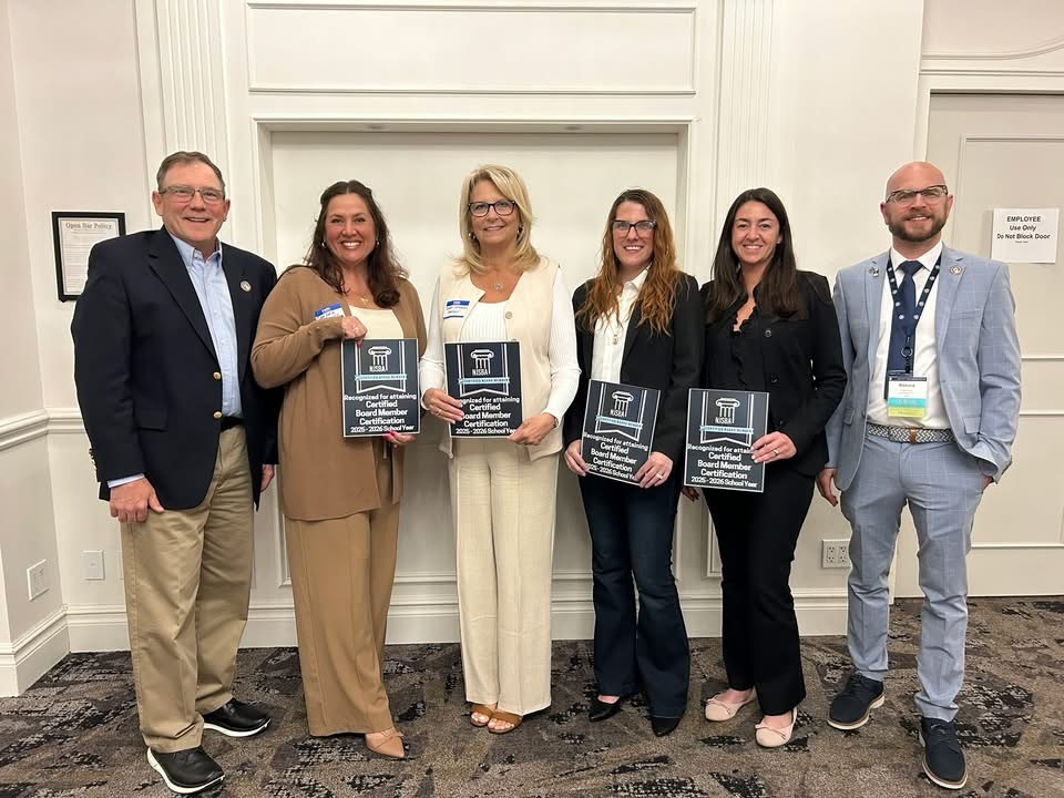Image of two BOE members holding plaques with two other Ocean County BOE members standing in between two School Boards members. 