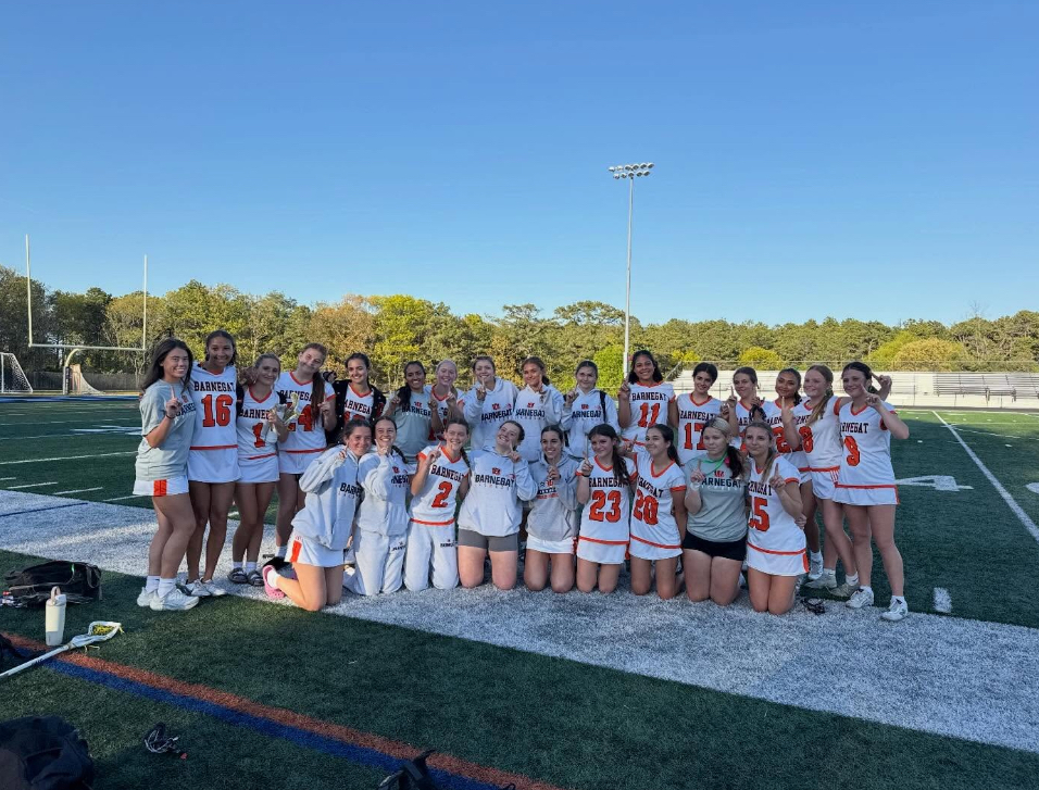 Image of the girls lacrosse team posing on the field after their championship win.
