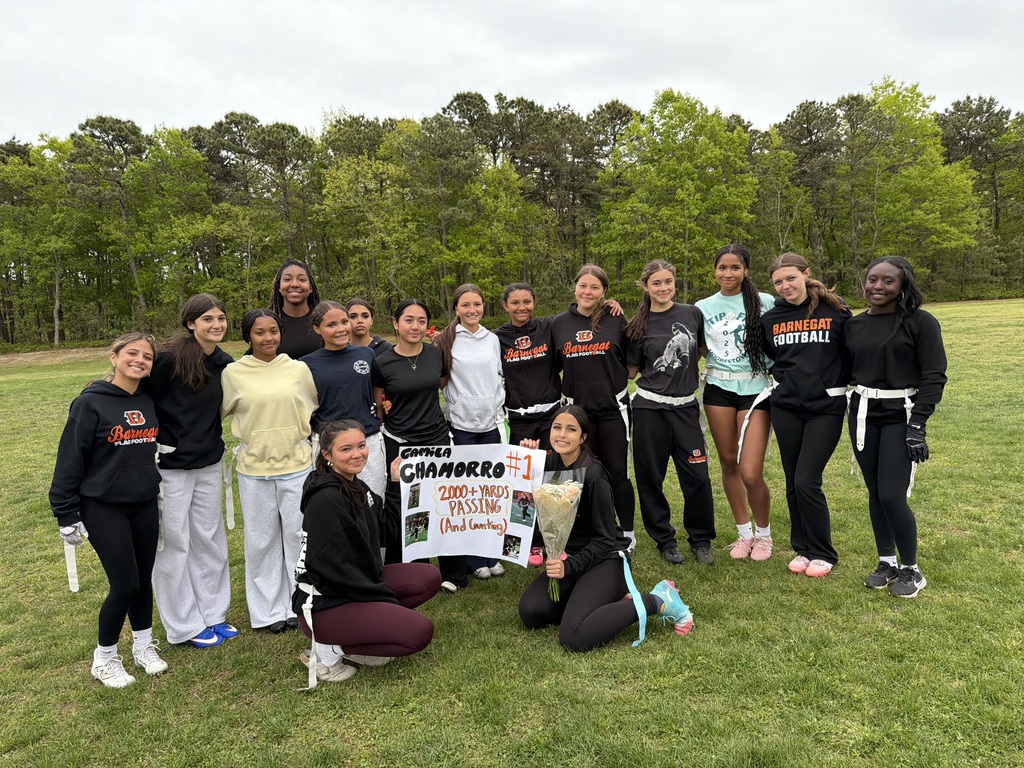Image of the girls flag football team holding a sign in support of Camila's 2,000 plus passing yards. 