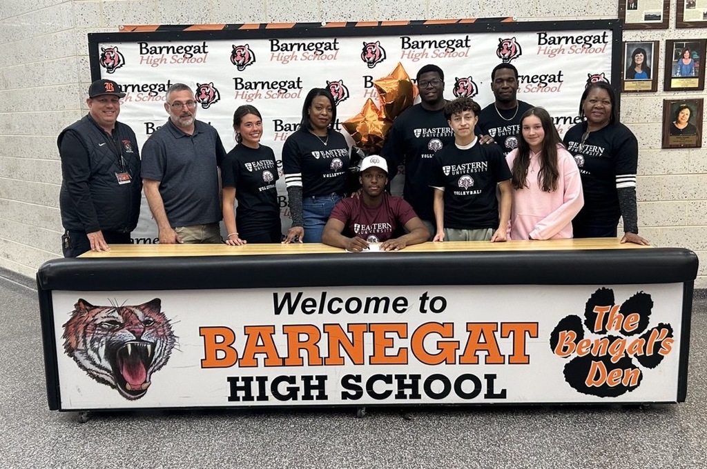 Image of Donovan posing with his coach, family, friends, and athletic director. 