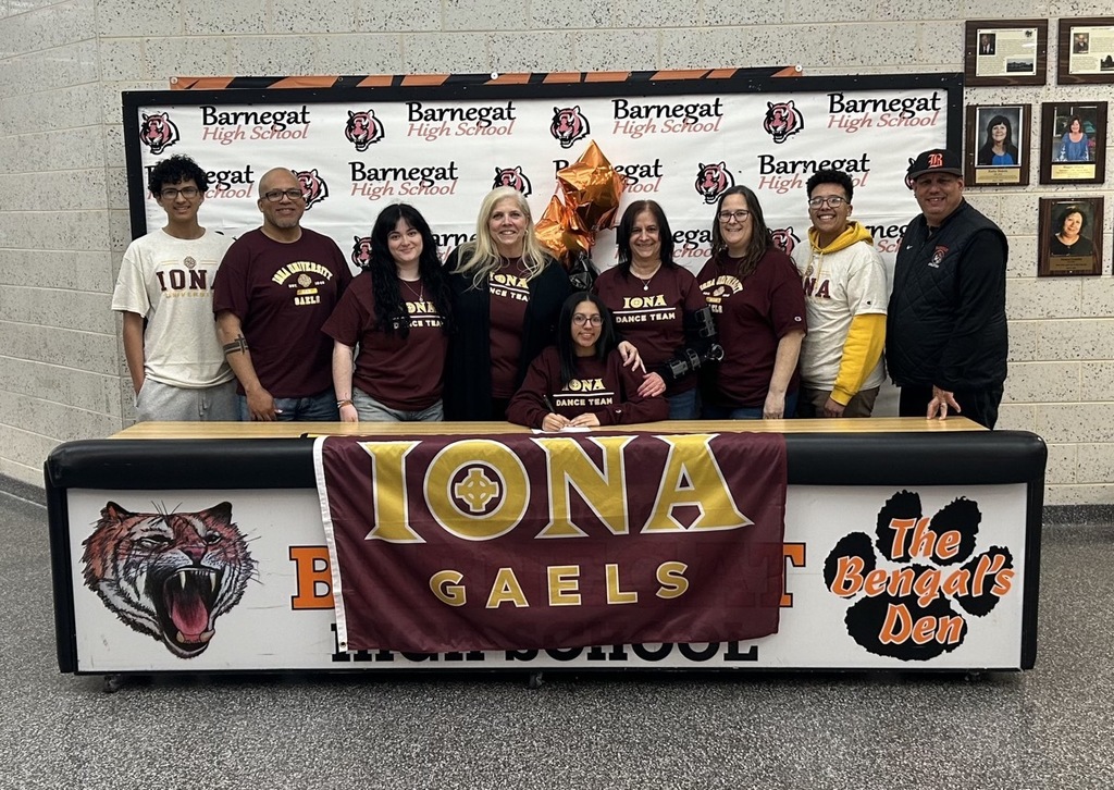 Image of Ava posing with her coaches, family, friend, and the athletic director. 