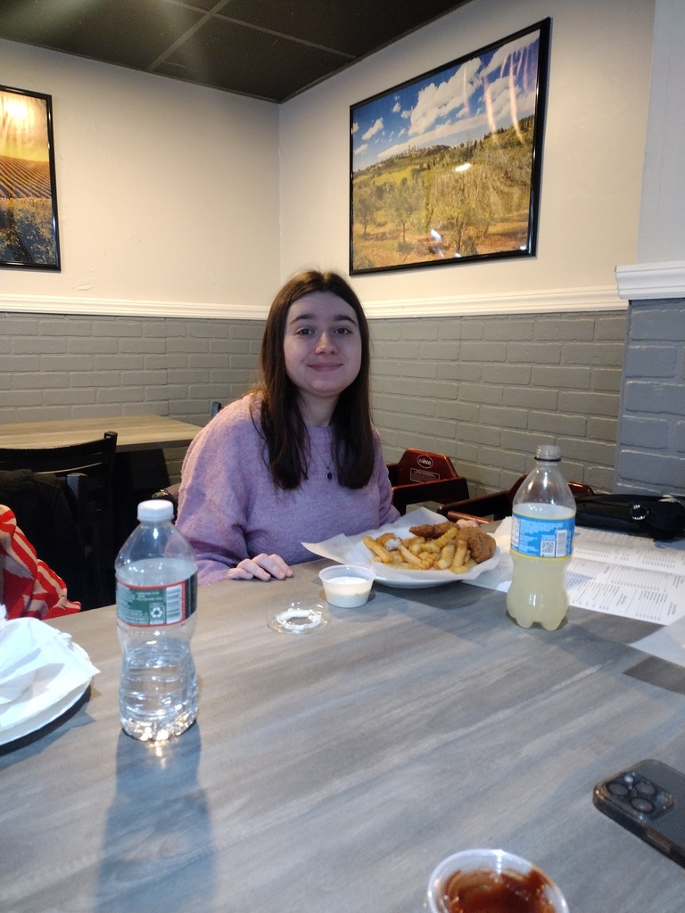 Image of Gianna sitting down at a restaurant enjoying a meal. 