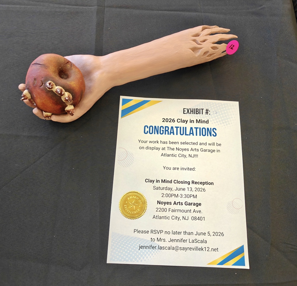 Image of the ceramic sculpture, a severed hand holding a rotting apple with a long bug coming out of it.  