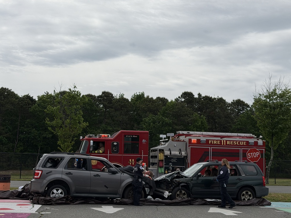 Image of the EMTs at the cars as a fire truck arrives at the scene.