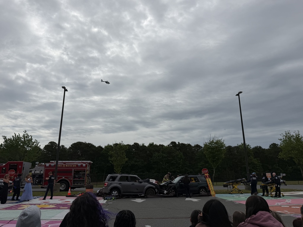 Image of the helicopter arriving on scene with police, fire, EMS working to remove the passengers from the car with the jaws of life.