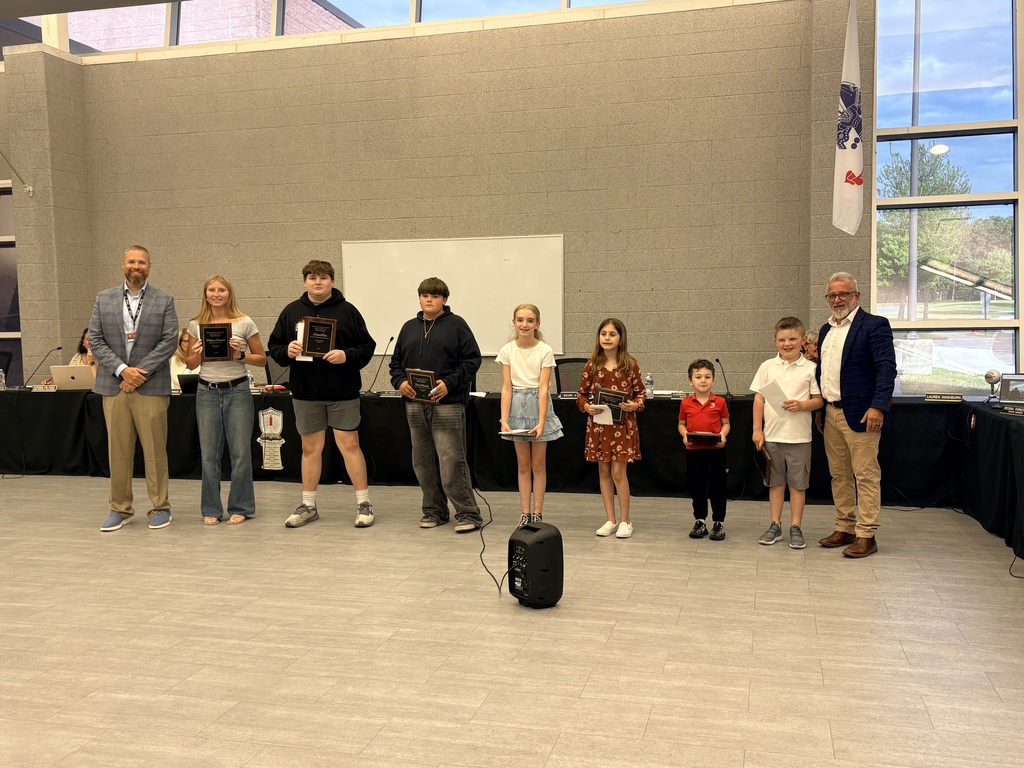 Image of the UPstanders holding their plaques, posing with the Superintendent and Board President.