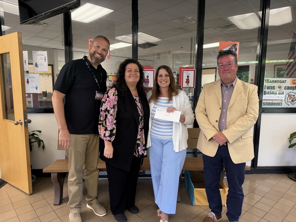 Image of Felicia posing holding an envelope with the Superintendent, Interim Assistant Superintendent, and Prinicipal.
