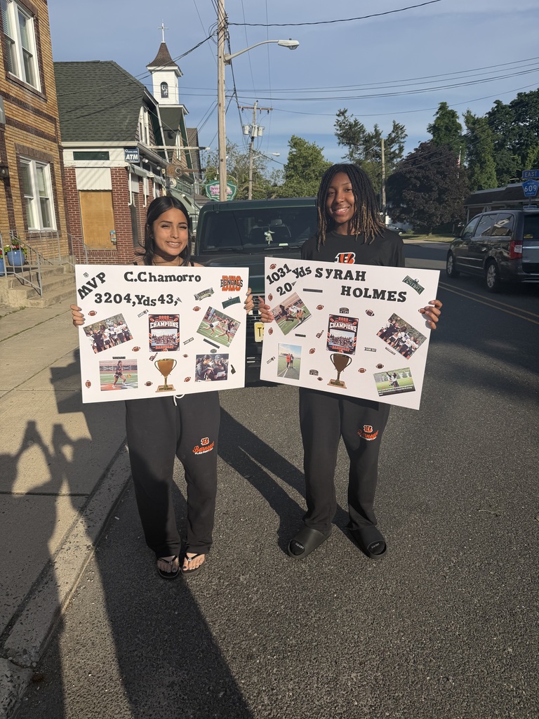 Image of Camila and Syrah holding signs with their accomplishments this season.