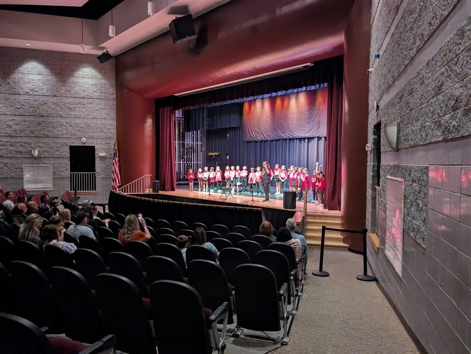 Image of the Collins School chorus performing on stage. 