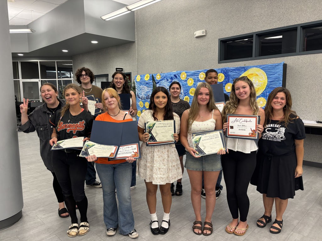 Image of the art award winners holding their certificates and posing with the art teachers. 