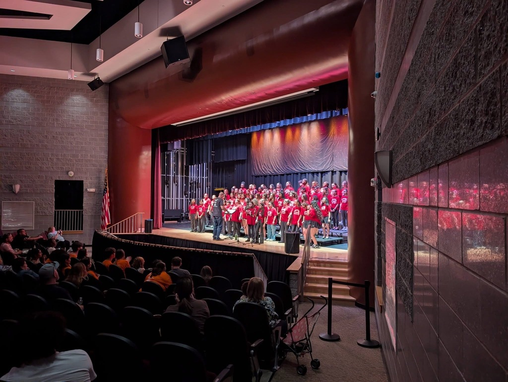 Image of the ROBMS chorus performing onstage under the direction of Mr. Wald. 