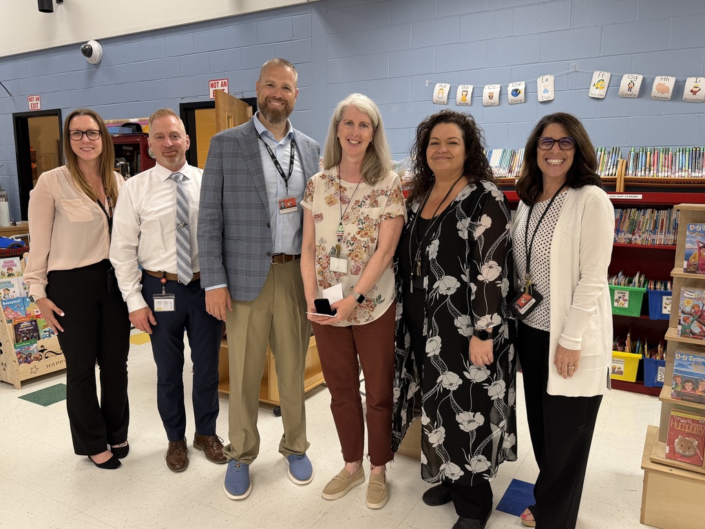 Image of Sarah posing with the Superintendent, Principal, and district administrators.