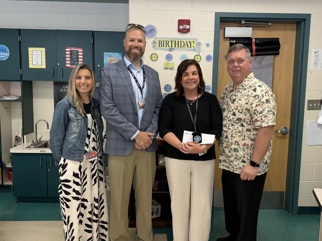 Image of Jennifer posing with the Superintendent, Principal and Vice Principal.