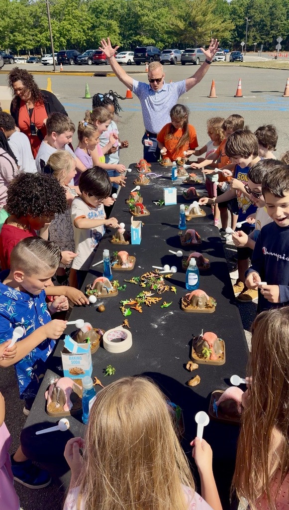 Image of the students adding vinegar to the baking soda and excitingly watching their volcanoes erupt. 