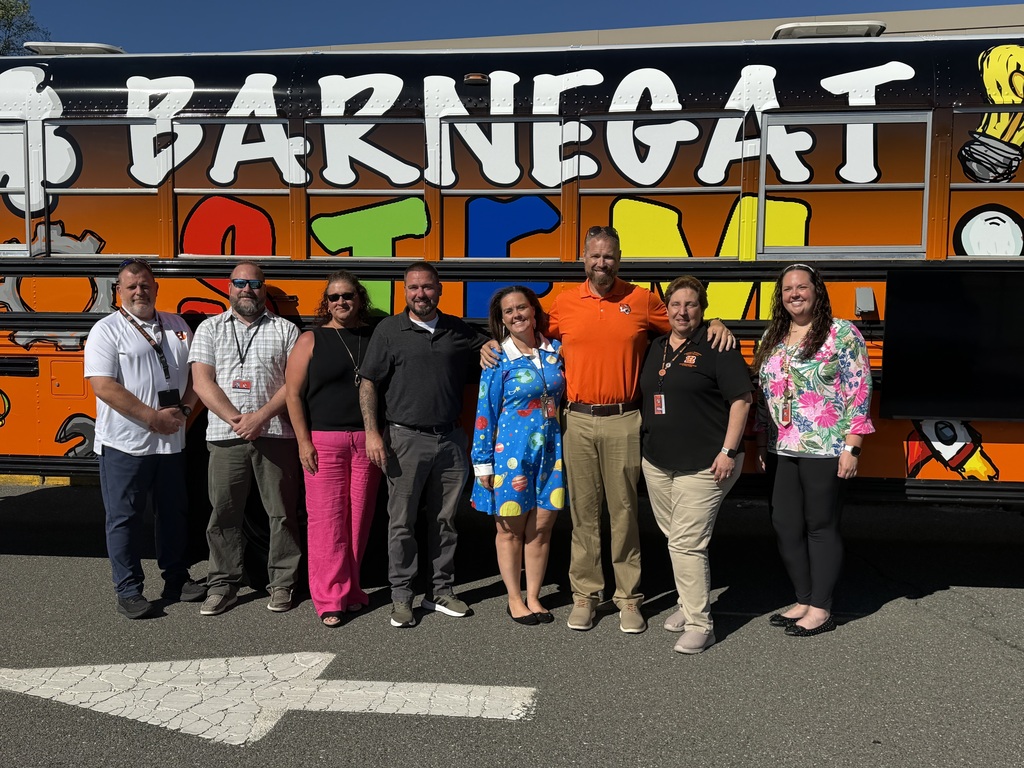 Image of the eight administrators posing in front of the STEM bus who were involved in bringing the idea to life. 