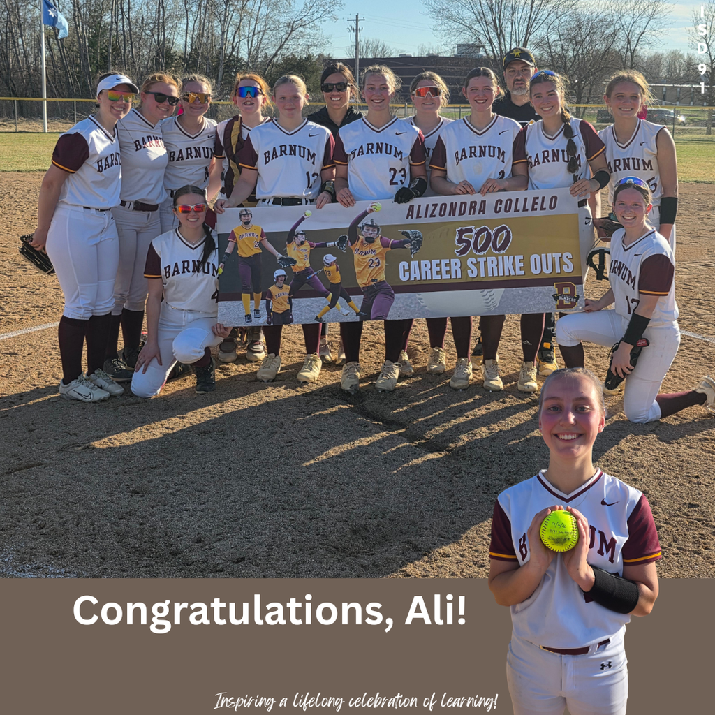 BHS Softball team posing with poster on softball field highlighting pitcher's 500th career strike out