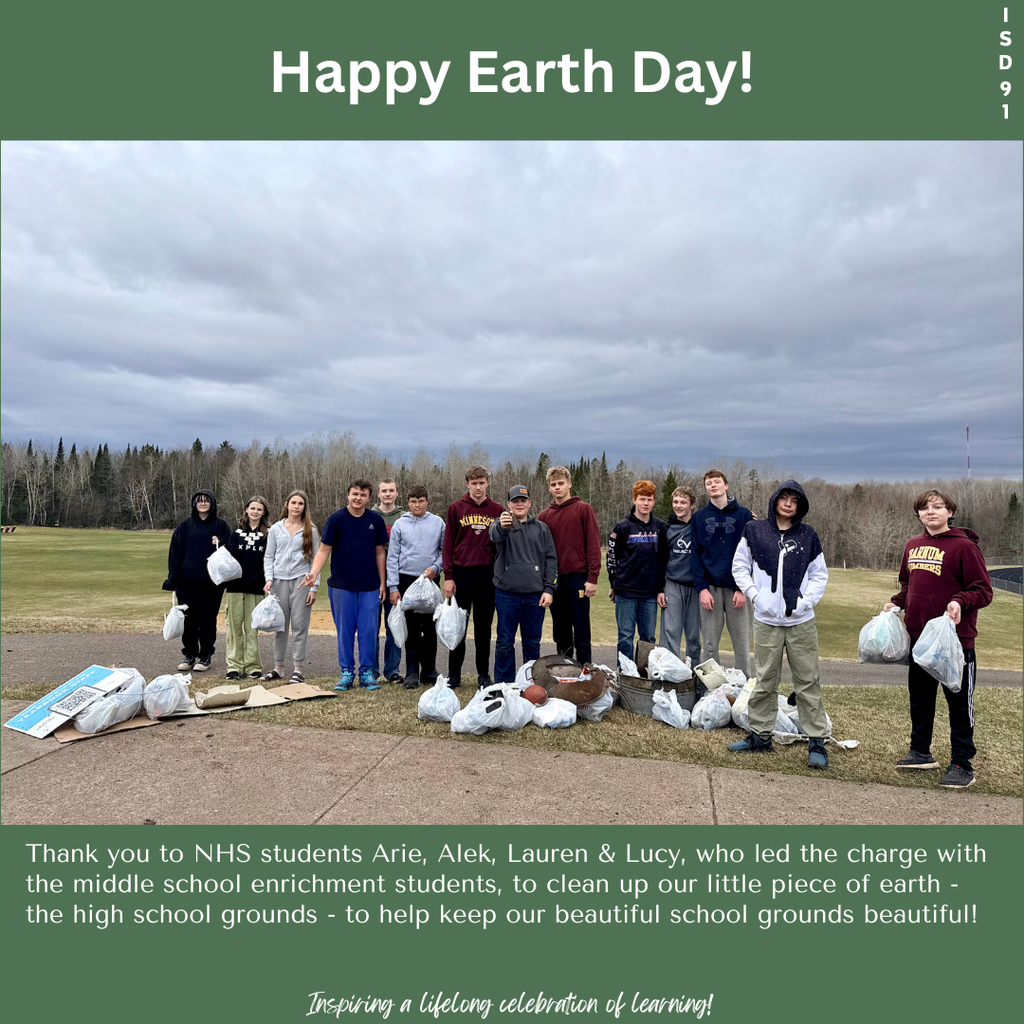 a group of students out back of the high school holding bags of garbage they cleaned up from the grounds