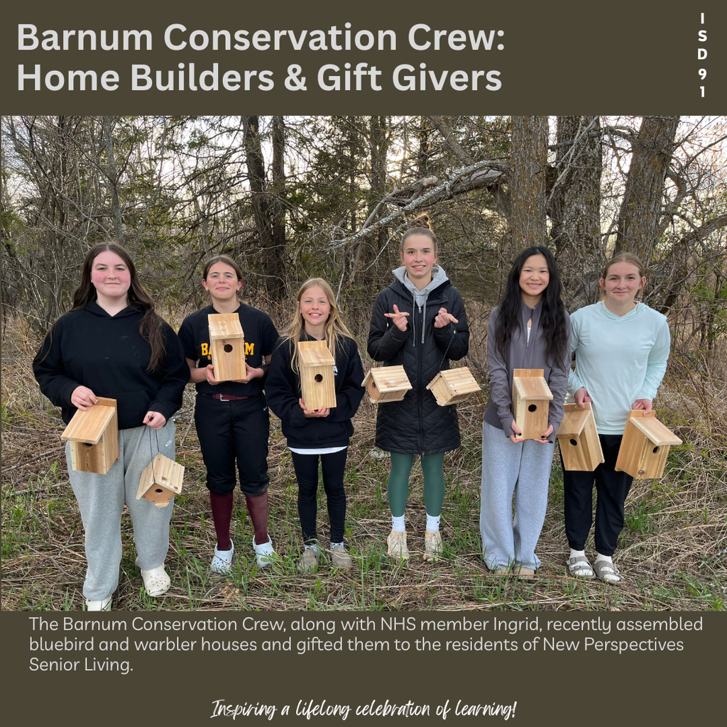 Six BES students and one BHS student stand on the edge of the forest holding up homemade bird houses