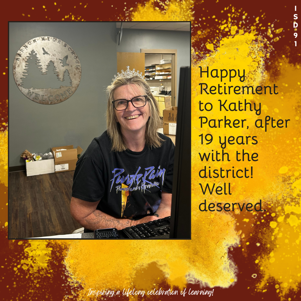 high school secretary sitting at desk smiling at camera