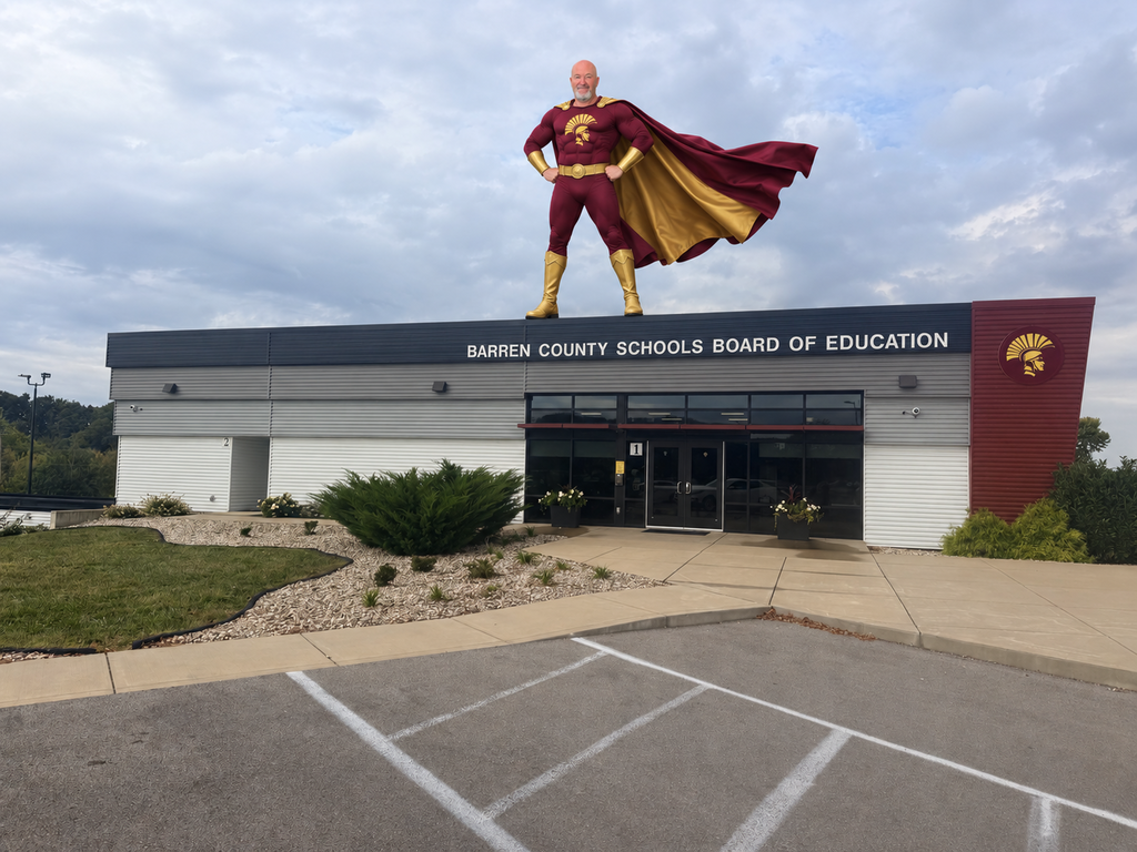 Mike Bragg AI image. He's dressed as a superhero standing on top of the Board Office.