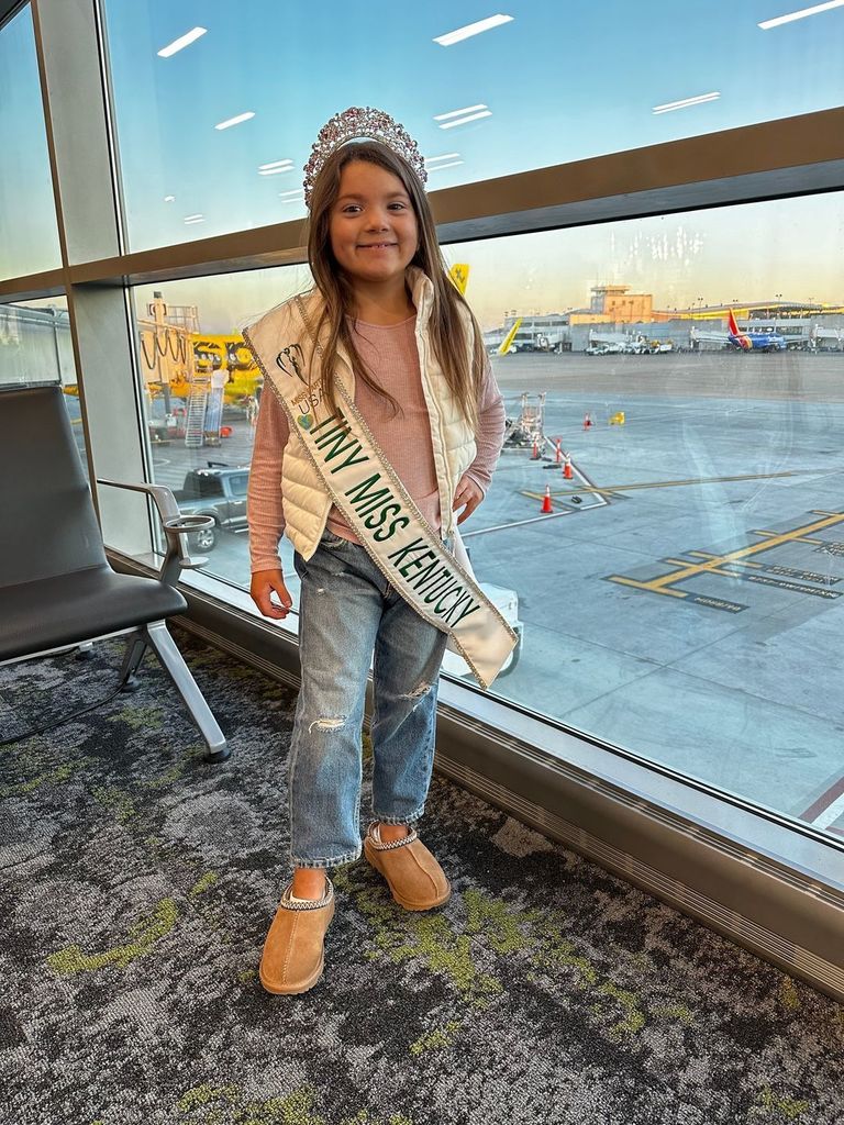 Acey Houchens in her sash and tiara, smiling