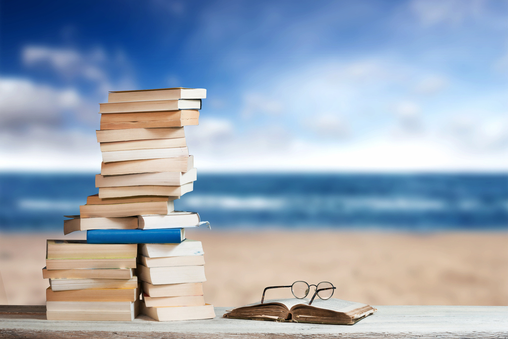 a stack of books at a beach