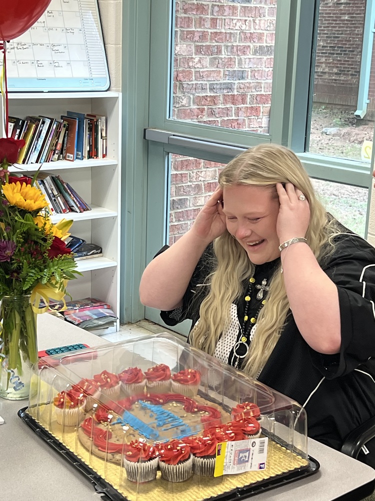 Teacher with cake showing joy and surprise on her face