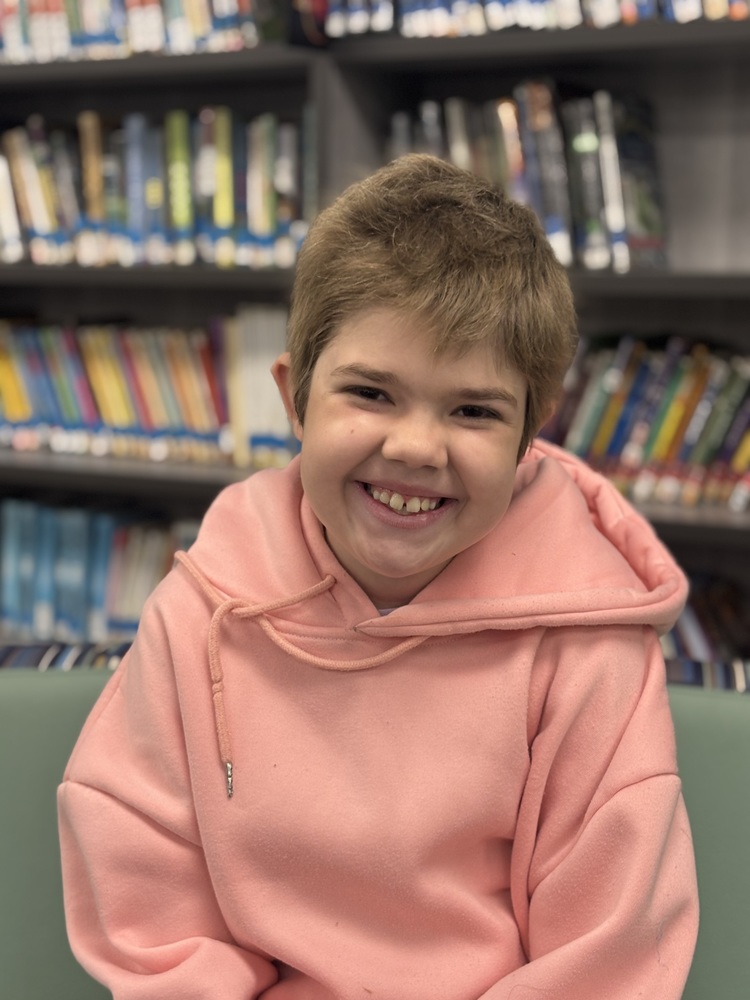 Girl with big smile sitting on a couch at HCES Hub