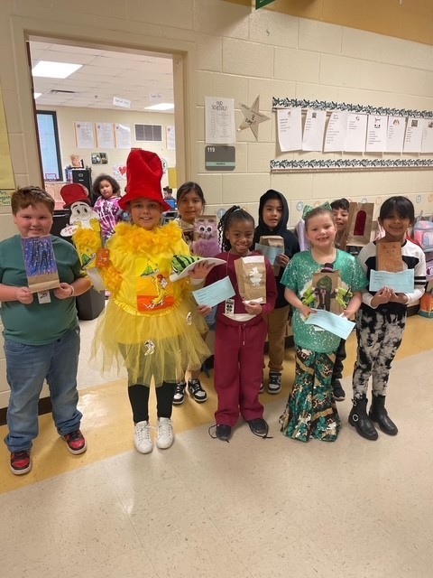 Second grade students smiling for a picture for Read Across America week.