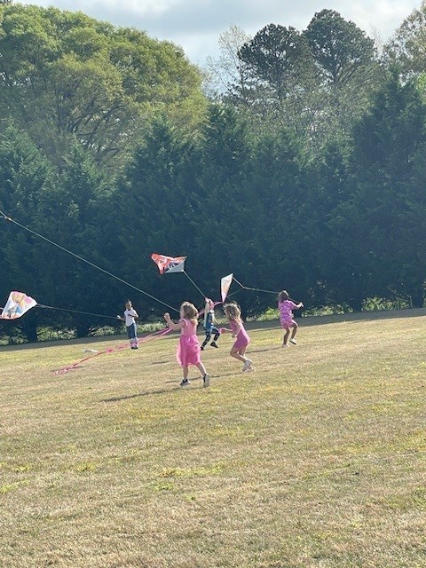 A group of students flying a kite outside.