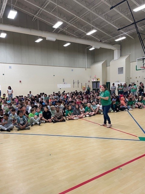 3-5th grade students sitting on the gym floor waiting on the Milestones pep rally to start