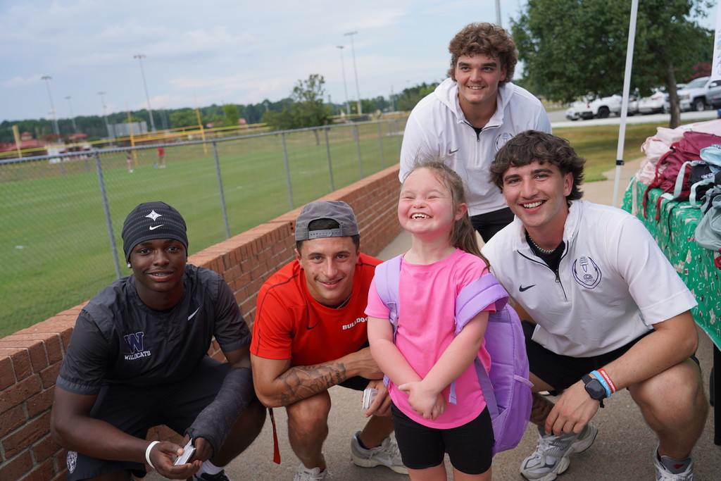 athletes handing out school supplies