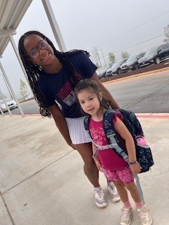 Woodland cheerleader helping a student in car riders