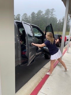 Woodland cheerleader opening a car door