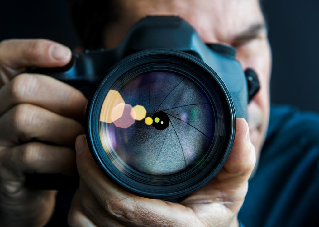 A close-up photograph of a camera in a person's hands