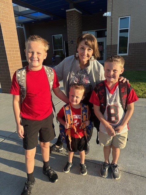 Assistant principal and students smiling for a picture on spirit day.