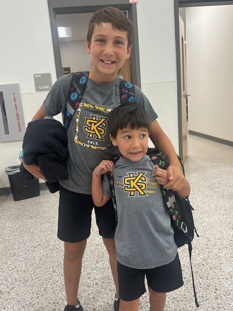Brothers smiling for a picture on spirit day.